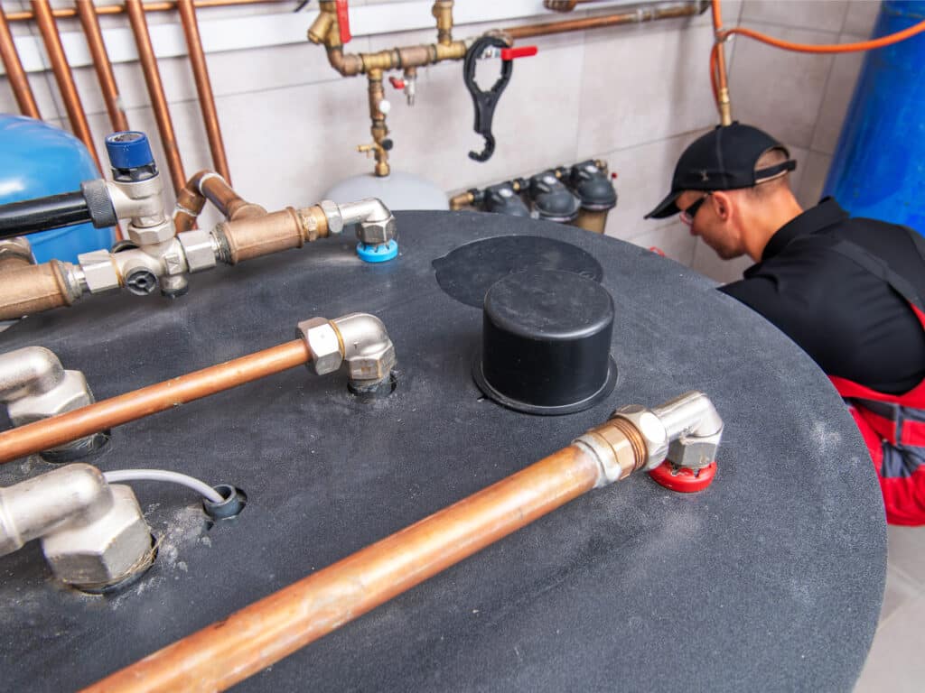 An engineering next to a buffer tank for domestic hot water system